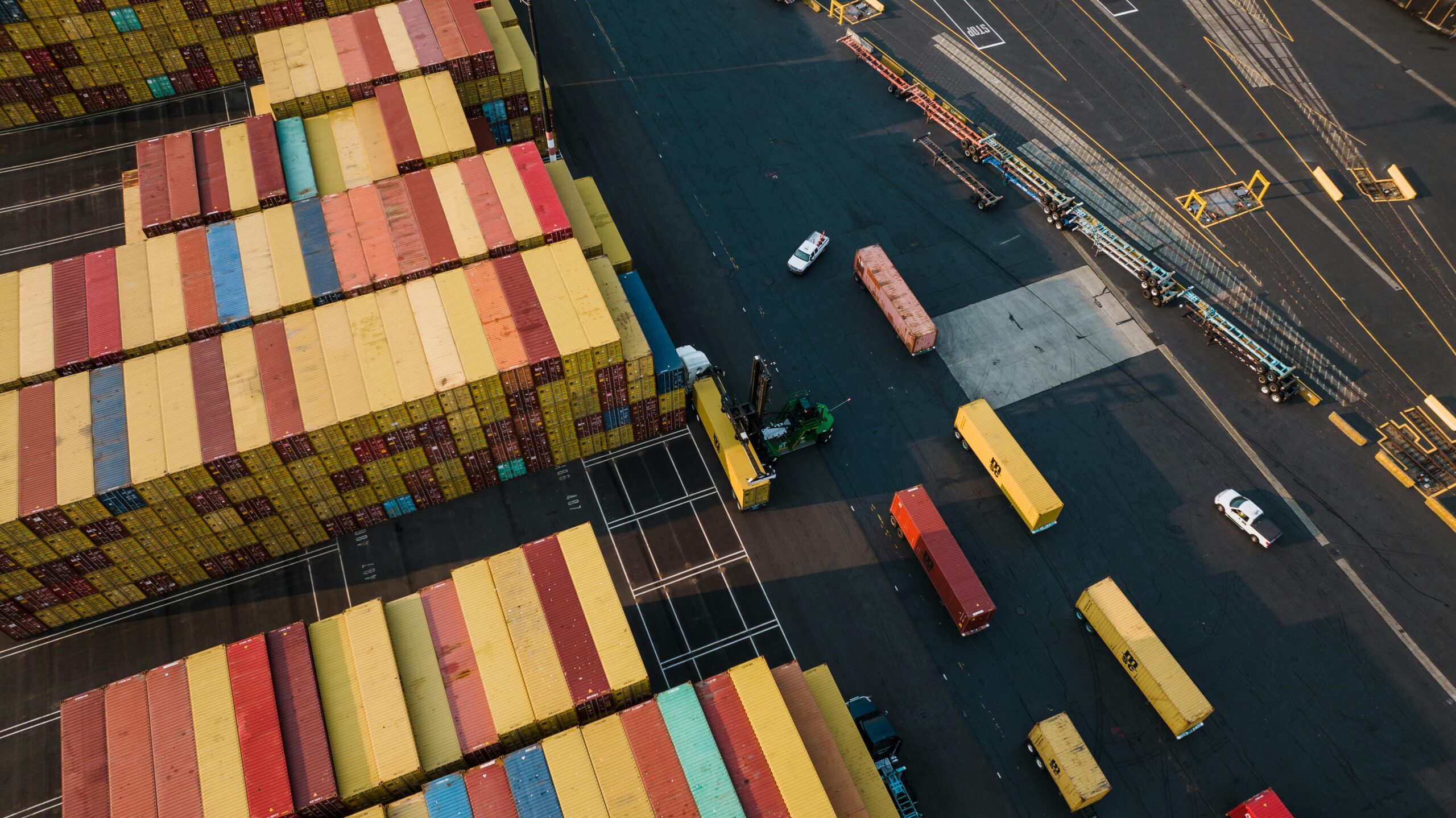 aerial view of port terminal with shipping containers and drayage trucks