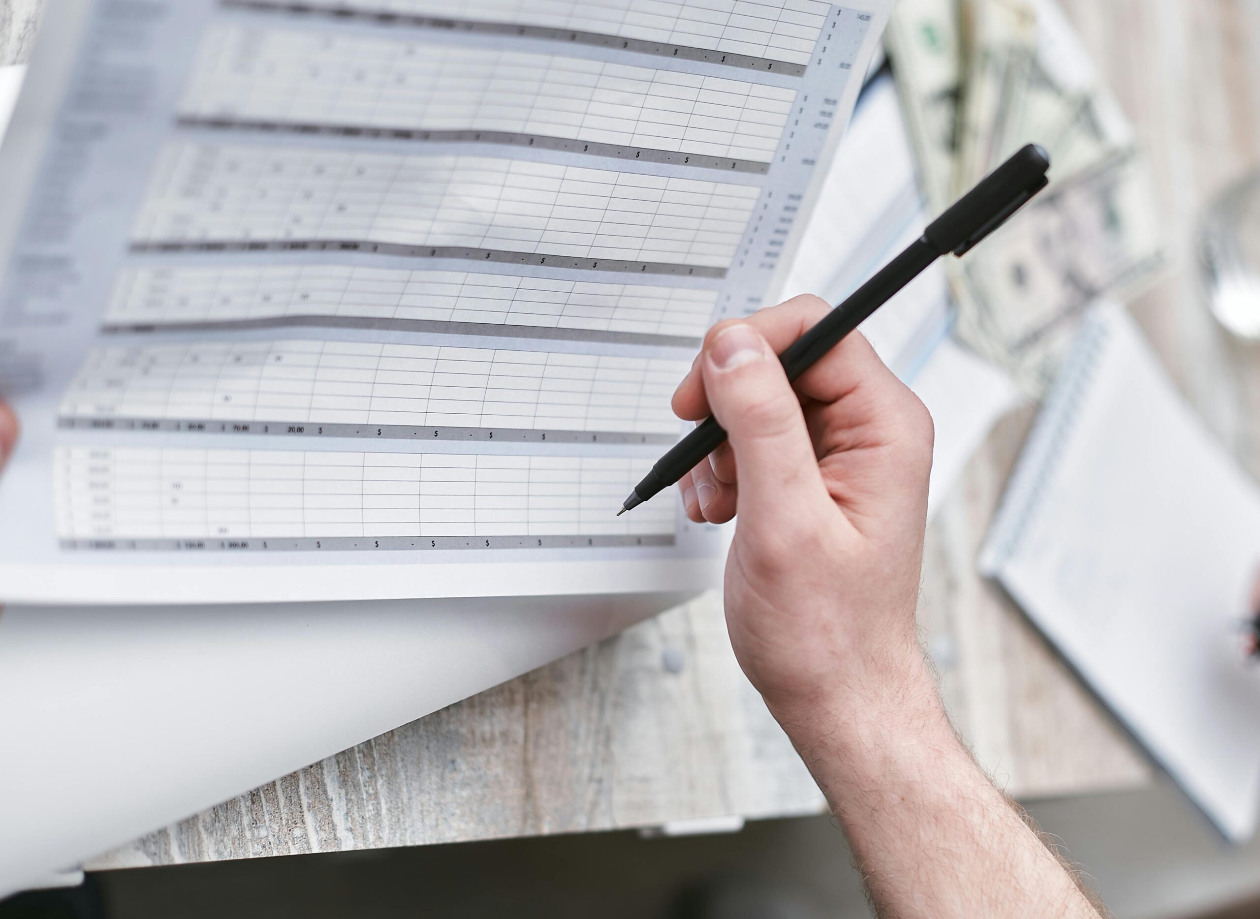 Freight rate audit — reviewing LTL shipping invoice data on printed spreadsheet
